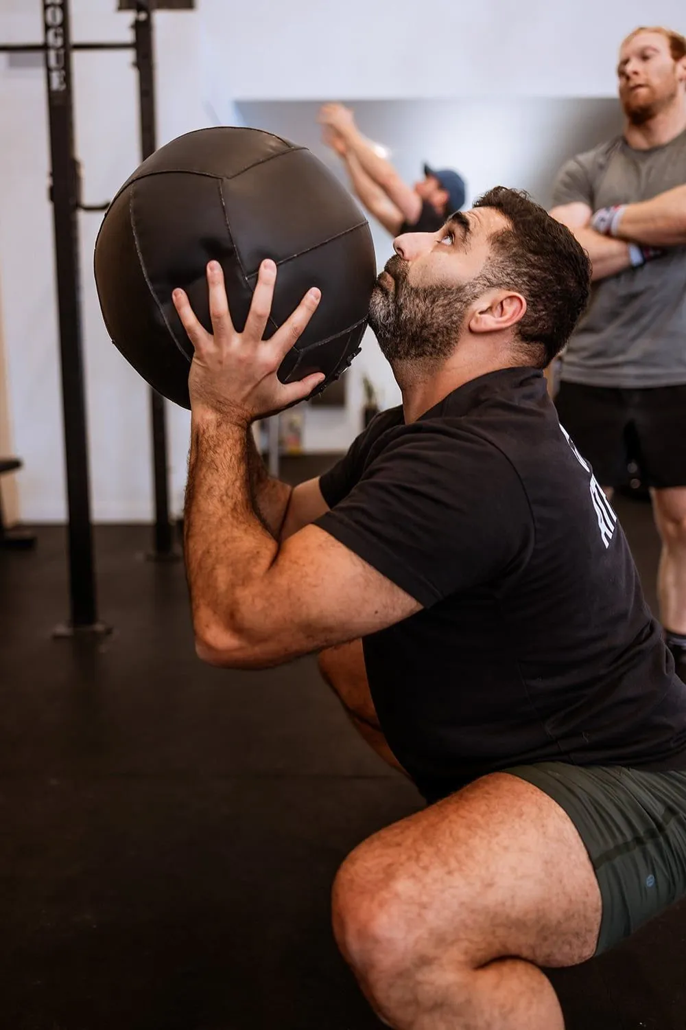 Athlete holding a medicine ball at the bottom of a squat