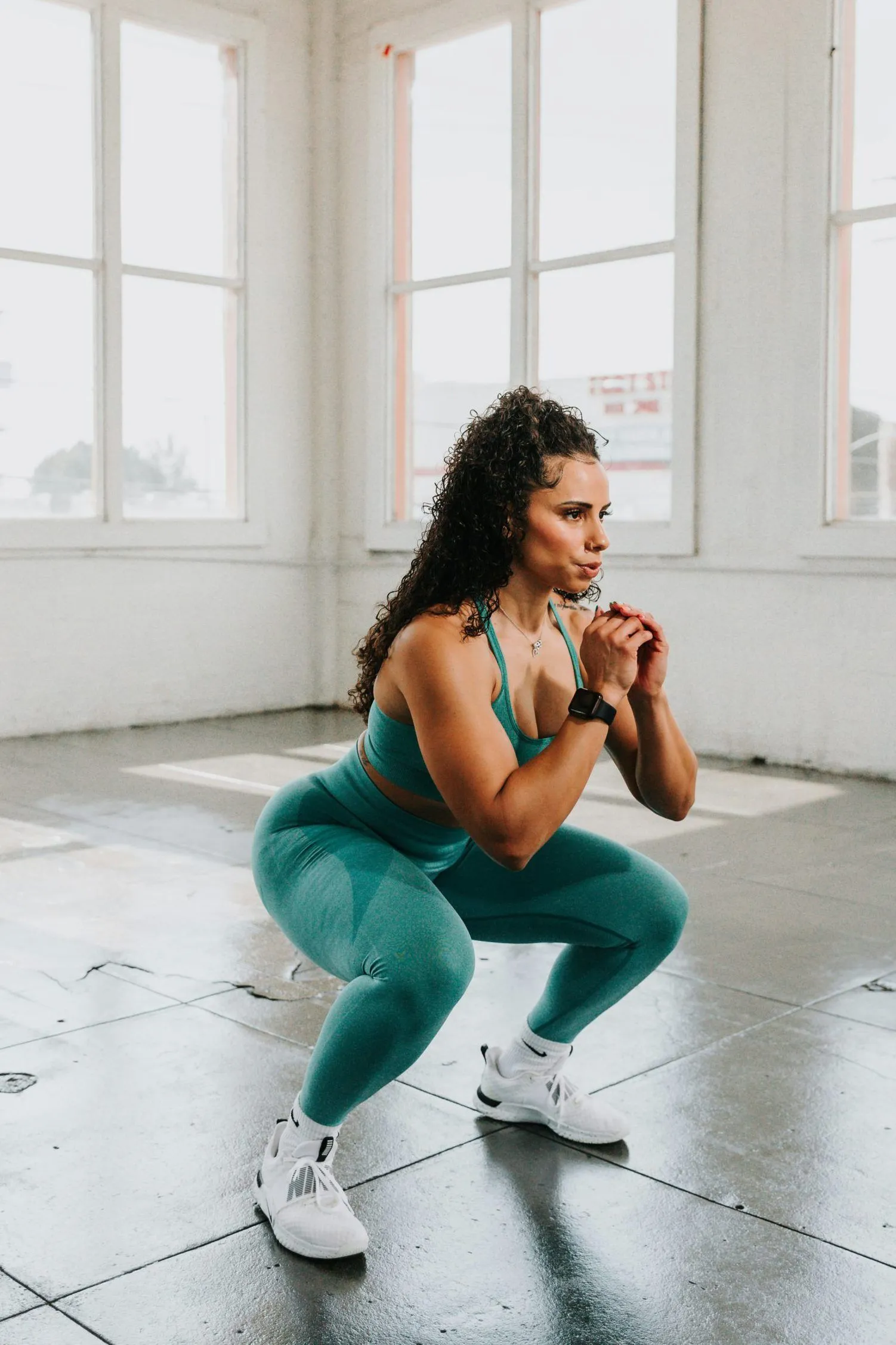 Athlete holding a deep squat in a bright studio
